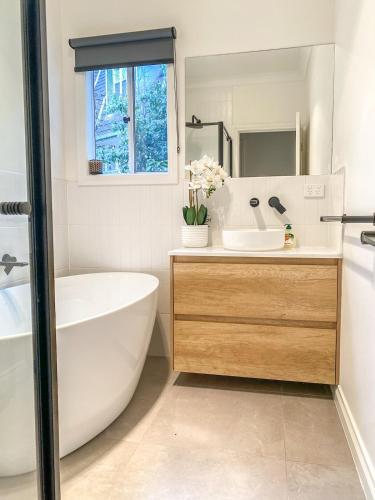 a white bathroom with a tub and a sink at Martyr Views in Warburton