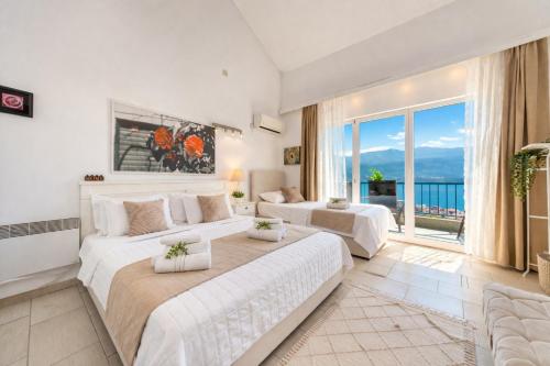 a large bedroom with two beds and a large window at Apartments Inspiration in Budva