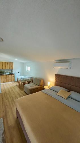 a bedroom with a large bed and a living room at JazAzur in Lastva