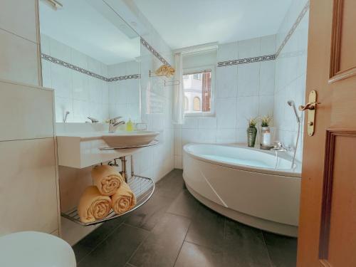 a white bathroom with a tub and a sink at Residence Chateau in Saas-Fee