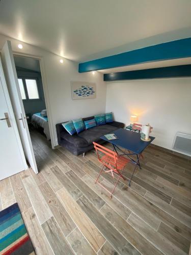 a living room with a couch and a table at Maisonnette de la mer in Hermanville-sur-Mer