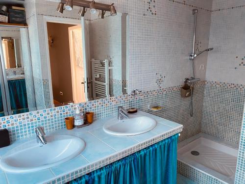 a bathroom with two sinks and a mirror and a tub at Maison 4 chambres in Carnac