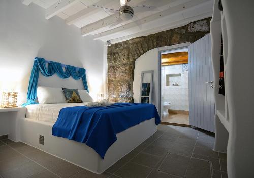 a bedroom with a blue bed and a bathroom at Salty Splash in Klima