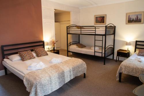 a bedroom with two beds and a bunk bed at 72QT in London