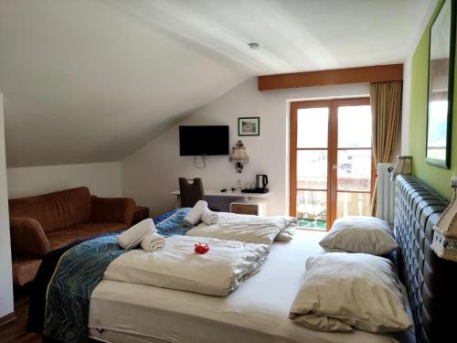 a bedroom with two beds and a couch at Hotel Pfrontener Hof in Pfronten