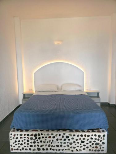 a bedroom with a bed with a blue comforter at Sunset Paradise Oia in Oia