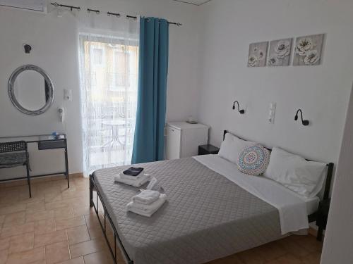 a bedroom with a bed and a mirror and a window at Hotel Liliana in Agia Marina Aegina