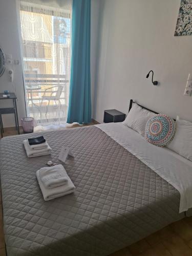 a bedroom with a bed with towels and a window at Hotel Liliana in Agia Marina Aegina