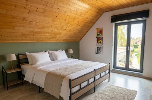a bedroom with a large bed with a wooden ceiling at MG Suites & Infinity in Ravels