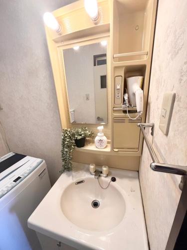 a bathroom with a sink and a mirror at High-speed Wi-Fi Station front Kamishinjo in Osaka