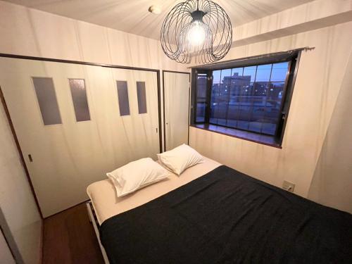 a small bedroom with a bed and a window at High-speed Wi-Fi Station front Kamishinjo in Osaka