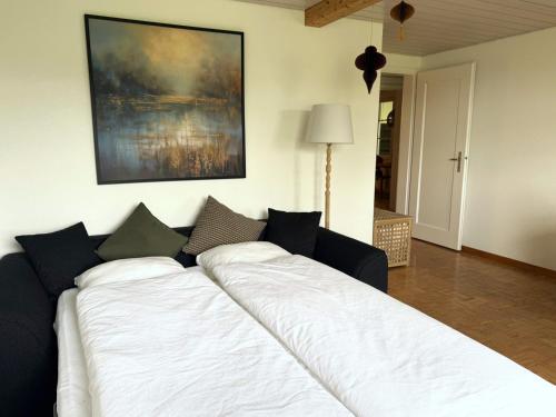 a large white bed in a living room at Bauernhaus mit Traumblick über Bern in Bolligen