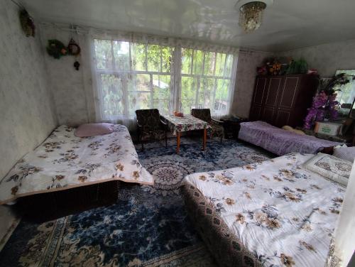 a bedroom with two beds and a table in it at Arslanbob guest house Mamajanov in Arslanbob