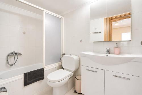 a white bathroom with a toilet and a sink at Avra breeze in Kriopigi