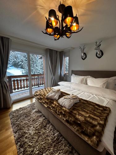 a bedroom with a large bed and a chandelier at Residence Chateau in Saas-Fee