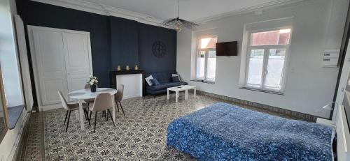 a bedroom with a bed and a table and a couch at Gite La Ferme du Château in Cerfontaine