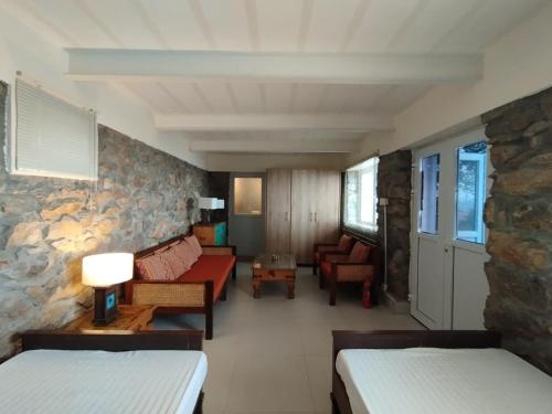 a room with two beds and a stone wall at HYN Mountain Resort in Kohāla