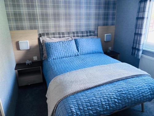 a blue bedroom with a bed with blue sheets and pillows at Blairgowrie in Ballintuim