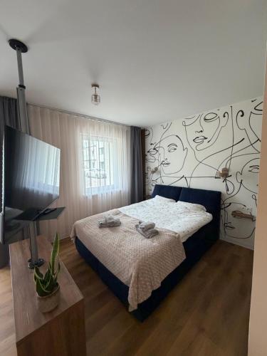 a bedroom with a bed and a flat screen tv at MG Apartament City Park in Szczecinek