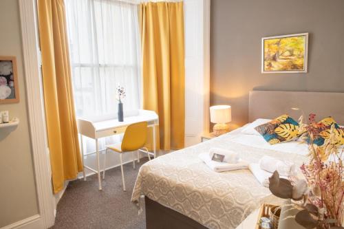 a bedroom with a bed and a desk and a window at 72QT in London