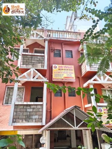 a pink building with a sign in front of it at Hotel Shahi Residency in Panhāla