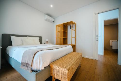 a bedroom with a large bed and a bench at Casa do Mar in Ribeira Grande