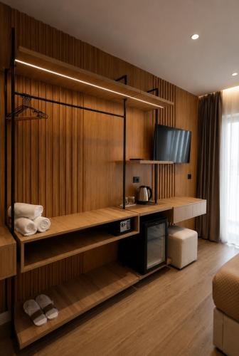 a living room with a wooden wall with a television at Albatros Beach & Resort in Rrogozhinë