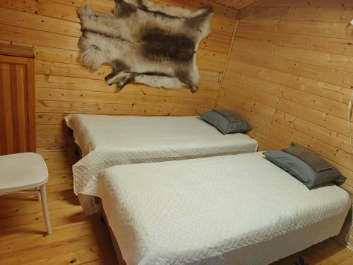 two twin beds in a room with wooden walls at Mere in Yarve-Keskranna