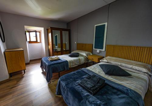 a hotel room with two beds and a mirror at Casa Laureano in Carcedo
