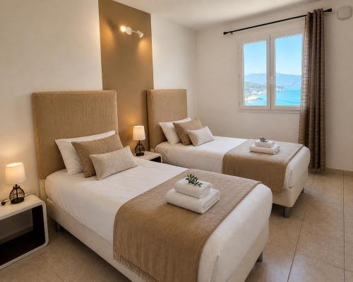 a hotel room with two beds and a window at Residence Arinella in Farinole