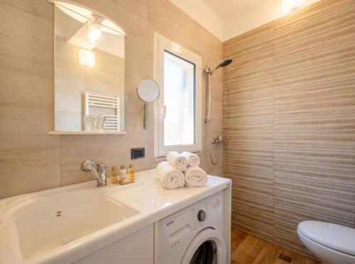 a bathroom with a sink and a washing machine at Casa Tino Panorama Skyline in Polignano a Mare
