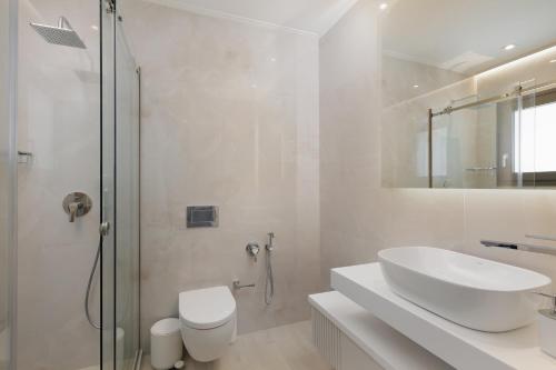 a white bathroom with a sink and a shower at Villa Eleni Di Mare in Kontokali