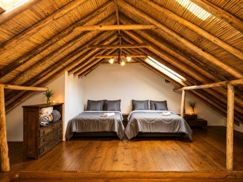 a attic bedroom with two beds and wooden floors at Hotel Pueblo Dorado Sesquilé in Sesquilé