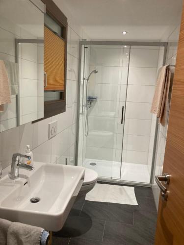 a bathroom with a white sink and a shower at Sole Mountain apartement in Zermatt