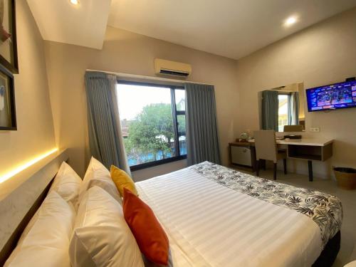 a bedroom with a bed and a large window at Hotel Sriti Magelang in Magelang