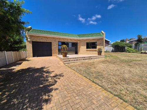 a brick house with a driveway in front of it at Sea side cottage in Stilbaai