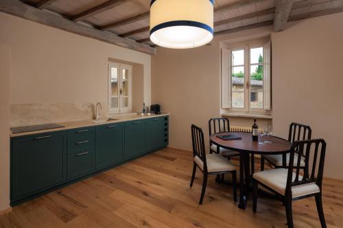 a kitchen with green cabinets and a table and chairs at Palazzo Saloni in Montalcino