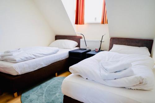 a room with two beds and a night stand at Haus am Skilift Postwiese in Winterberg