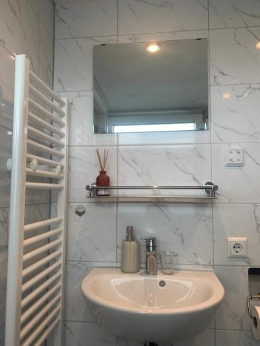 a white bathroom with a sink and a mirror at Bed en Breakfast 1394 in Nederhorst den Berg