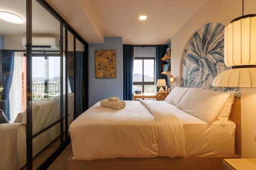 a bedroom with a bed with a teddy bear on it at Luxury Designer Studio Sealy Bed Coffee Bar Walk to Cicada Market & Beach in Hua Hin