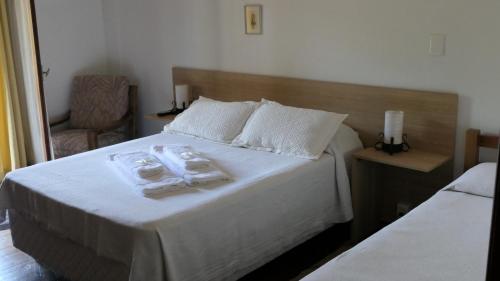 a bedroom with a bed with towels on it at SUIZO Hotel in Colonia Suiza