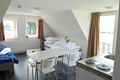 a room with two beds and a table and chairs at Gouden Plakje in Gaastmeer