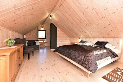 a bedroom with a bed and a desk and a chair at VIP forest dreams villa 2 in Leliūnai