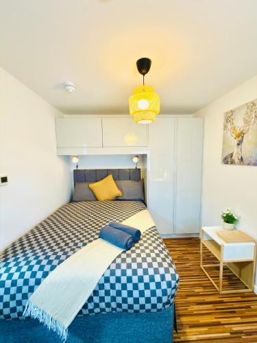 a bedroom with a bed with a checkered blanket at Britlodge Ruskin Stay in Manchester