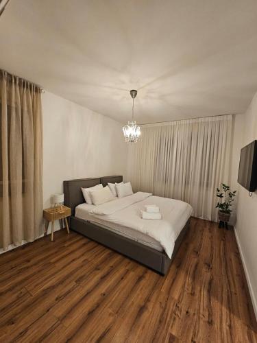 a bedroom with a large bed and a chandelier at פינה בשדה in Sede Naẖum