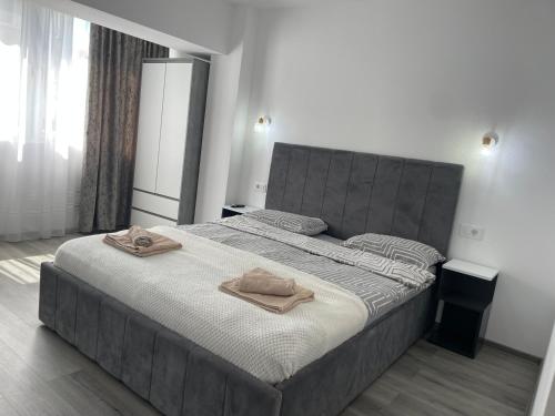 a bedroom with a large bed with two towels on it at Cristal Residence in Zalău