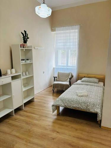 a bedroom with a bed and a chair and a window at House1890 in Kula