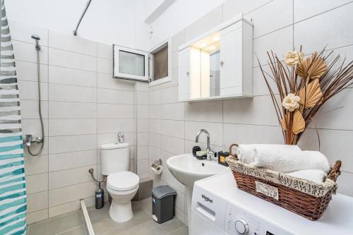 a white bathroom with a sink and a toilet at Anthia studio in Koutsourás