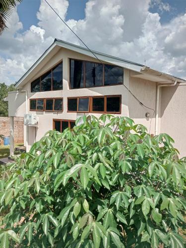 a white house with a bush in front of it at Laker's barn in Gulu