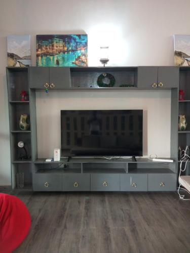 a living room with a large entertainment center with a flat screen tv at Laker's barn in Gulu